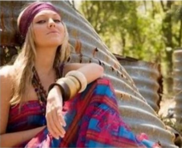 image of girl dressed like a hippie sitting in the grass
