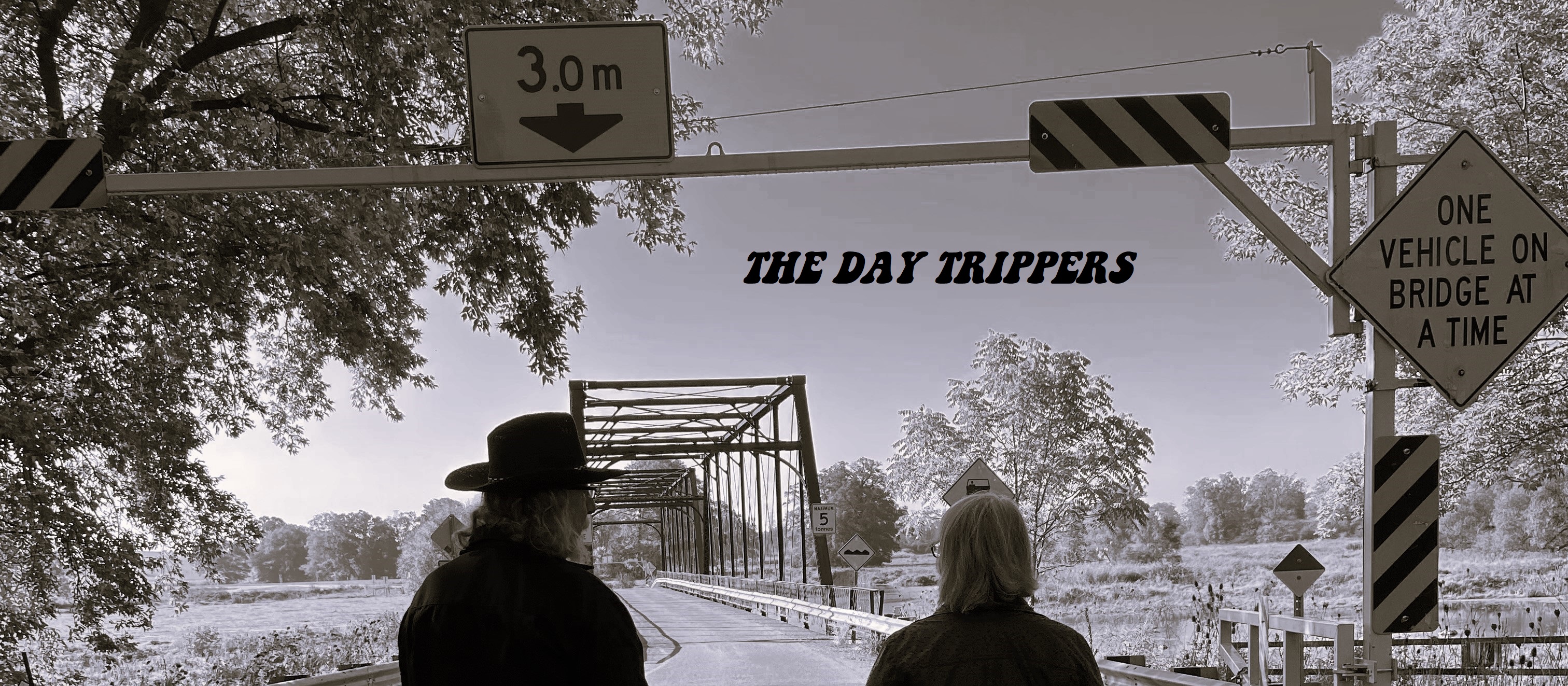 image of The Day Trippers duo walking away onto a bridge