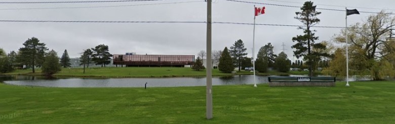 image of factory on large grassy property with a pond and fountain in front