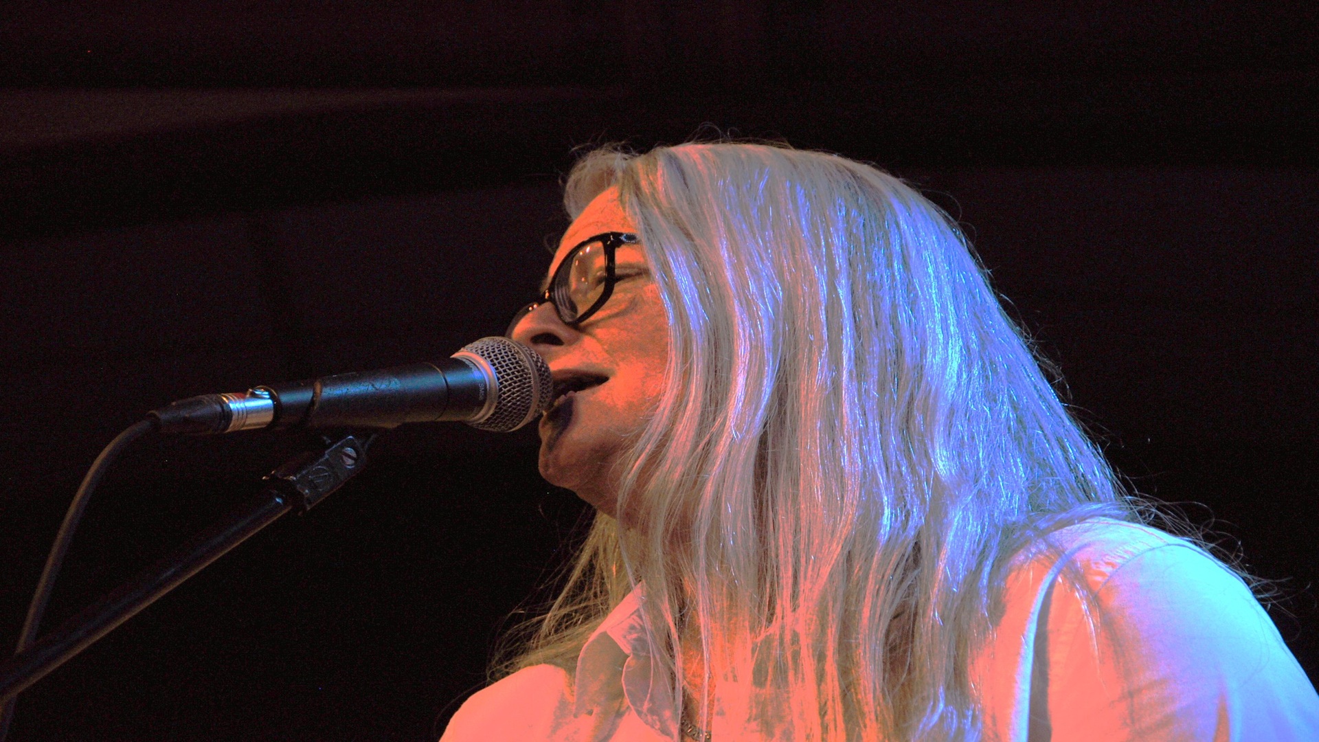 image of Lori singing into microphone